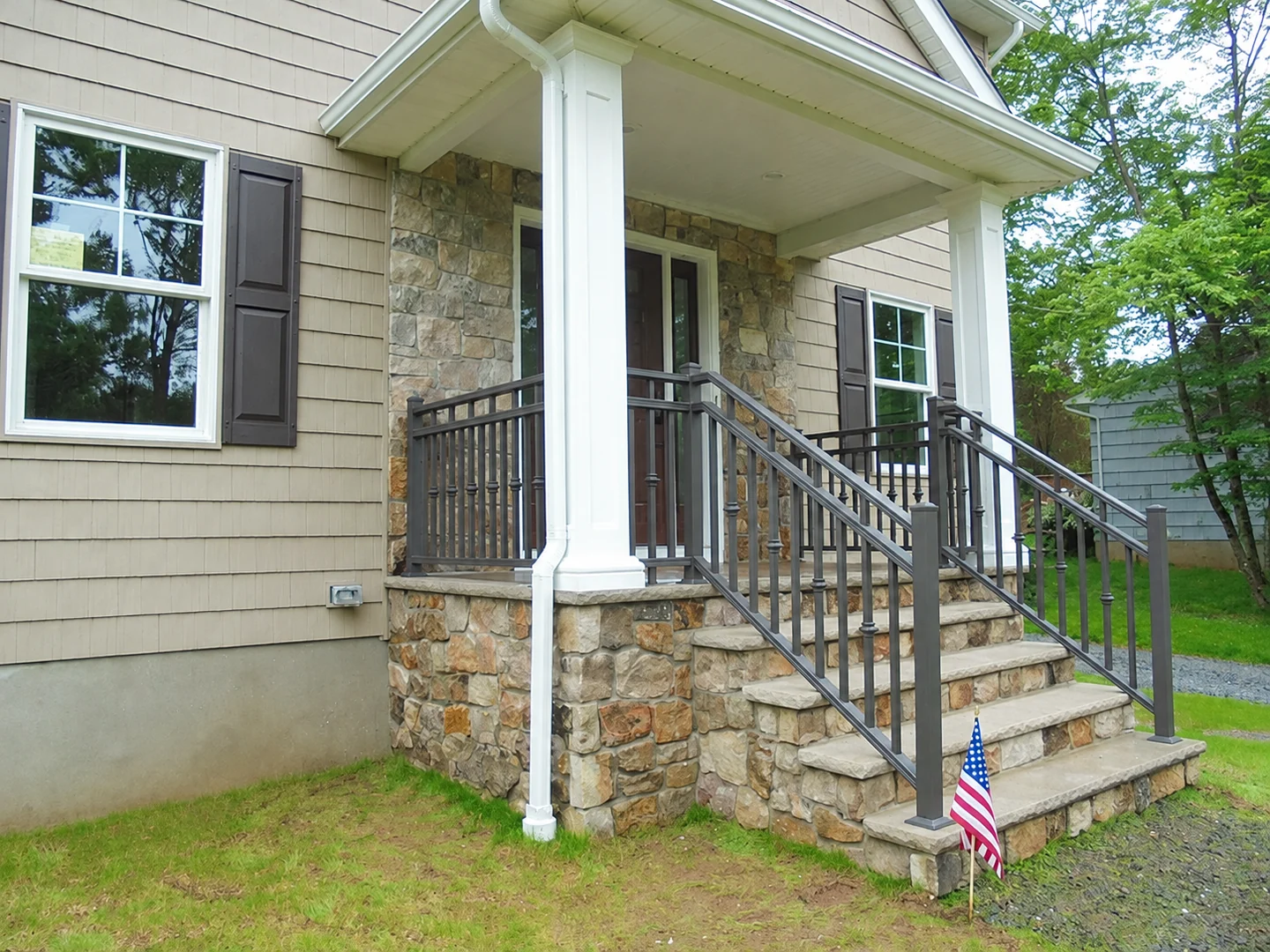 Dark aluminum picket railings with decorative collars on stone residential front steps