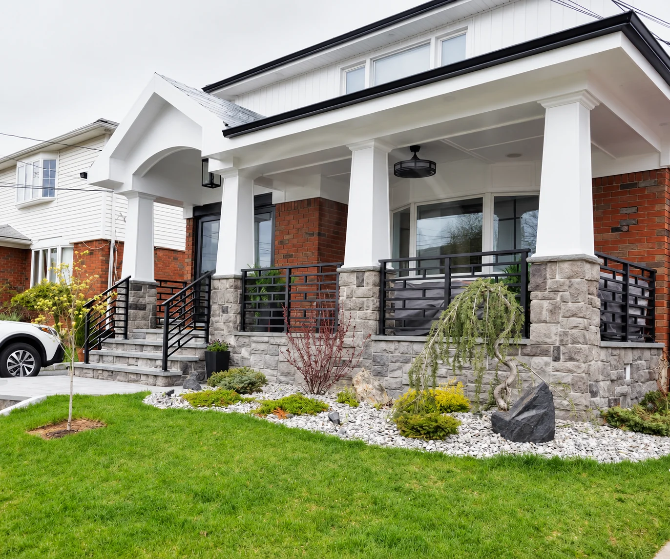 Black horizontal-picket railings around a finished white residential porch and entry steps
