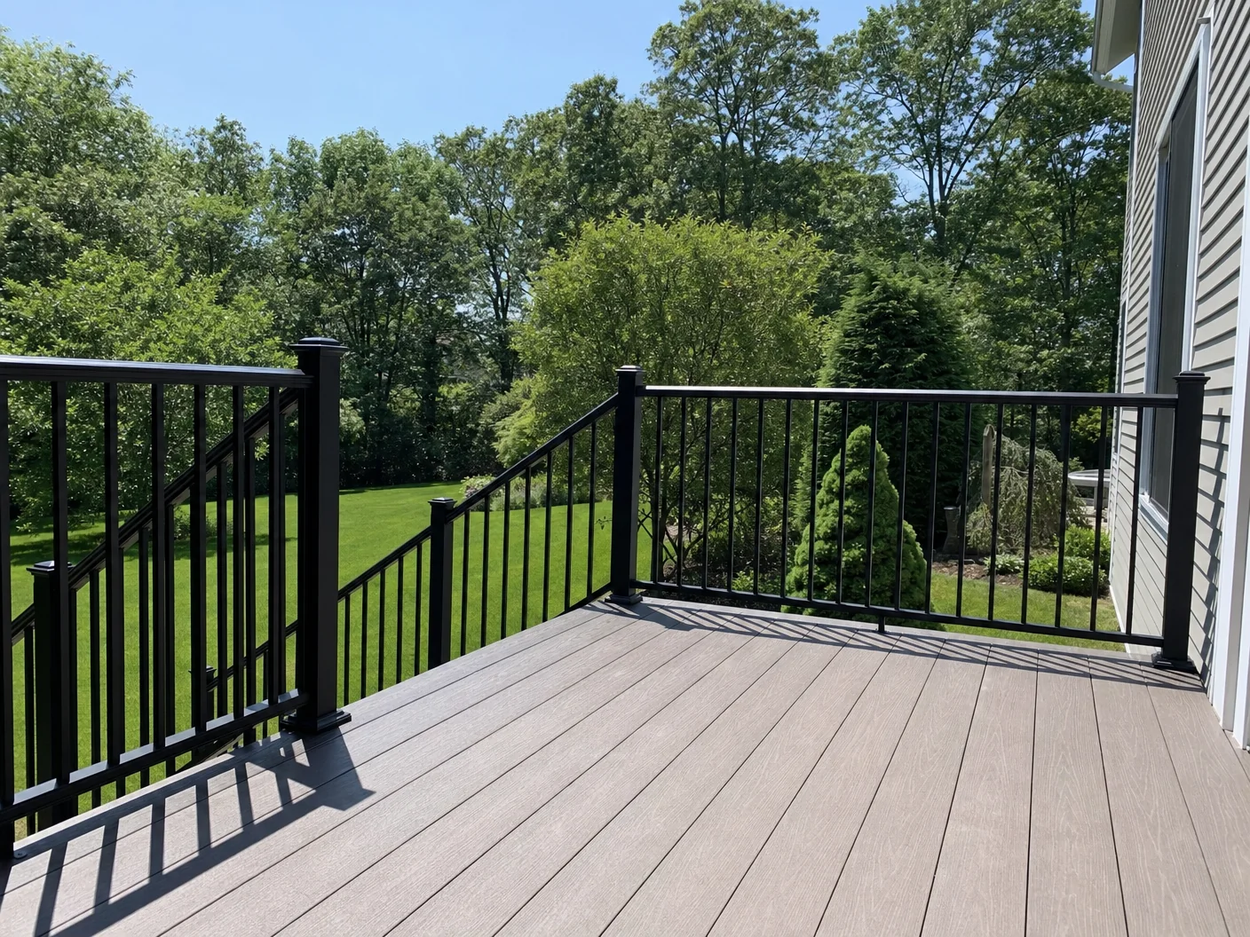 Black aluminum vertical-picket railing on a residential deck and stairway